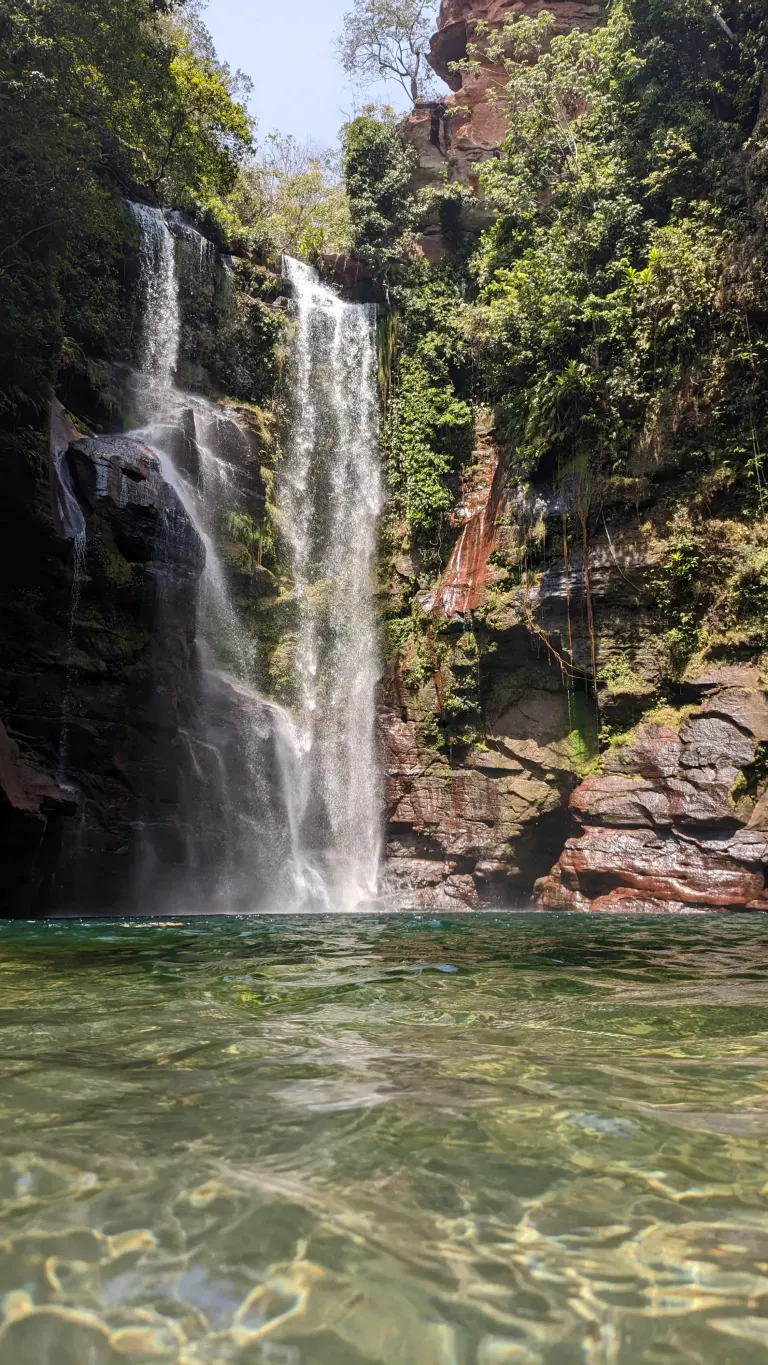 Vista de frente da Cachoeira Azul, queda d'água de mais de 40 metros caindo em um poço de água cristalina