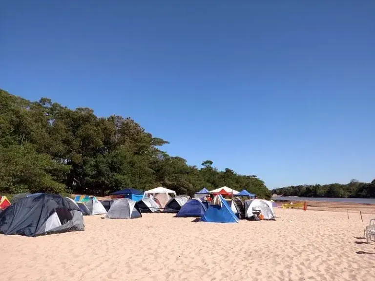 barracas de camping montadas na areia da Praia da Arara em dia de céu azul