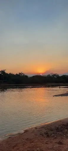 o sol está se pondo bem baixo no rio já próximos das arvores