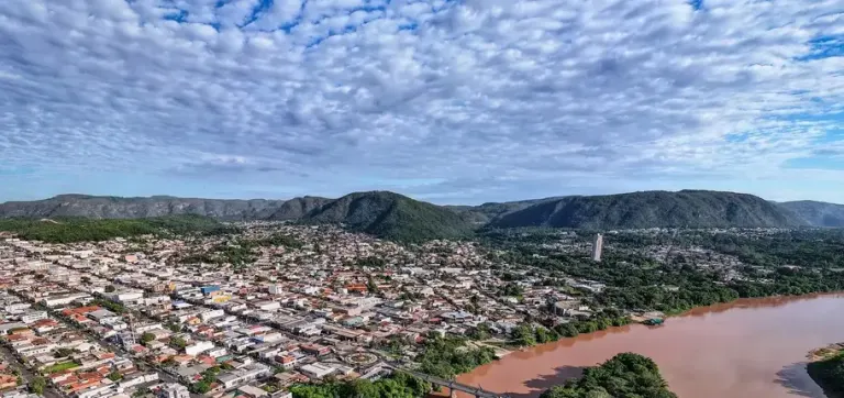 Vista aérea panorâmica de Barra do Garças, com a serra, o Rio Araguaia e céu parcialmente nublado